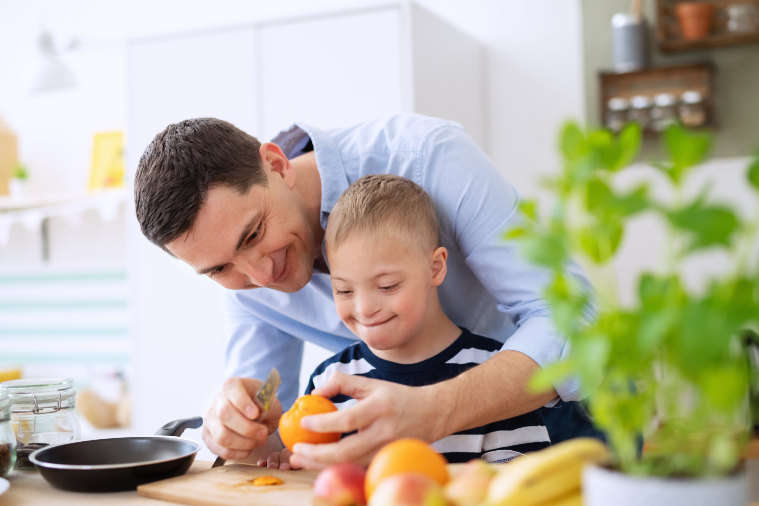 Father,With,Happy,Down,Syndrome,Son,Indoors,In,Kitchen,,Preparing